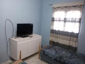 a room with a tv on a dresser with a window at Casa Marcelo in Salta