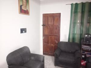 a living room with two chairs and a door at Casa Marcelo in Salta