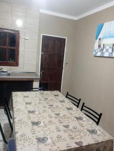 a dining room with a table and chairs and a kitchen at Casa Marcelo in Salta