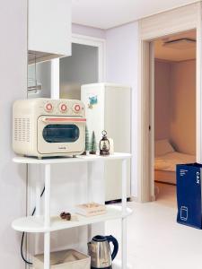 ソウルにあるNew Building All rooms Aircondition 지하철도보5분 동대문15분 명동25분 이태원성수서울역30분の白い棚に電子レンジ