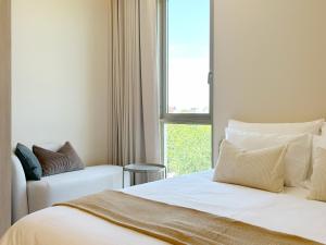 a bedroom with a white bed and a window at Peace Nakhon Nayok in Nakhon Nayok