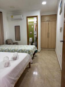 a hotel room with two beds and a bathroom at Janeth’s Place Apartamento in San Andrés +13 photos