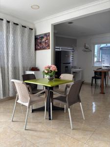 a dining room with a green table and chairs at Janeth’s Place Apartamento in San Andrés