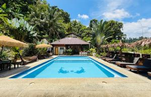 a pool at a resort with two people on it at Victordelia Hilltop Hostel in San Vicente