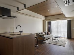 a kitchen with a sink and a living room at Band Hotel Hakata in Fukuoka