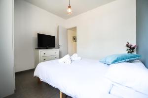 una camera con 2 letti e una TV su un comò di Holiday Apartment Alona a Eilat