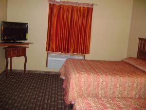 a hotel room with two beds and a television at Camino Real Hotel in Eagle Pass