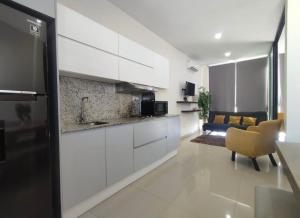 a kitchen with white cabinets and a living room at Departamento en Mazatlán in Mazatlán