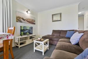a living room with a couch and a table at Dolphin View on South Esplanade in Bongaree