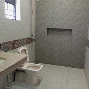 een badkamer met een toilet, een wastafel en een douche bij Ayyan Cottage F 10 in Islamabad
