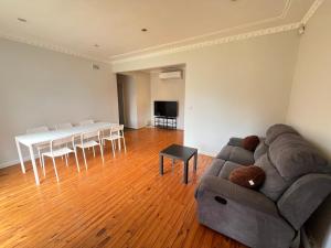 a living room with a couch and a table at Cozy Queen Room next to Shopping Centre and Station - SH5 in Toongabbie West
