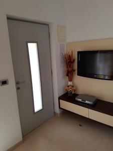 Habitación con puerta, ventana y TV. en Apartment Lency en Novigrad Istria
