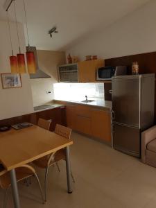 a kitchen with a table and a stainless steel refrigerator at Apartment Lency in Novigrad Istria