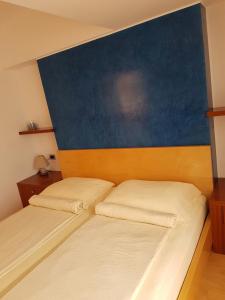 a bedroom with a bed with a blue headboard at Apartment Lency in Novigrad Istria