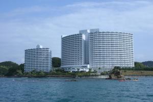 two tall buildings in front of a large body of water at Hotel Harvest Nankitanabe in Tanabe