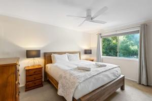 ein Schlafzimmer mit großem Bett und Fenster in der Unterkunft 26 Gannet Street, Peregian Beach in Peregian Beach