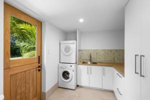 eine Küche mit Waschmaschine und Spüle in der Unterkunft 26 Gannet Street, Peregian Beach in Peregian Beach + 7 Fotos
