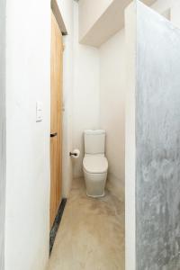 ein Badezimmer mit Toilette in einem weißen Raum in der Unterkunft Jungla Hotel Boutique in San Cristóbal de las Casas