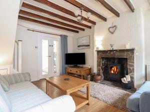 een woonkamer met een bank en een open haard bij Riverside Cottage in Caernarfon