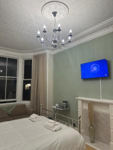a bedroom with a bed and a tv on the wall at Luxury King Room In the Heart Of Edinburgh in Edinburgh