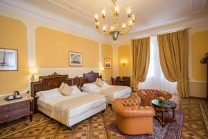 a hotel room with two beds and a chandelier at Hotel Bristol Palace in Genoa +93 photos