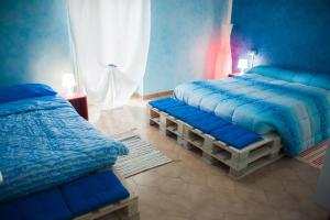 1 dormitorio con 2 camas y edredones azules en B&B Casa Tua, en Castelfrentano