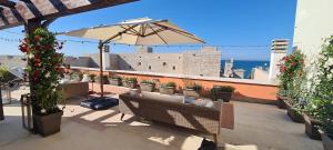 a patio with chairs and an umbrella and plants at Luxury Sea Palazzo in Trani