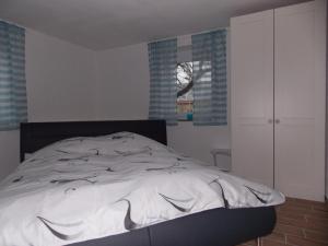 a bedroom with a bed with a white comforter at Ferienhaus Hofmann Strüth 3 in Röttingen