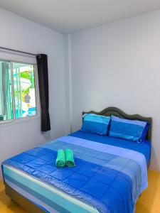 a bed with a pair of green slippers on it at BAN SINGH TO Poolvilla in Cha Am +25 photos