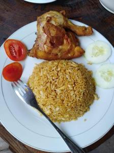 a plate of food with rice and meat and a fork at Vakantie Vila Wab in Watnil