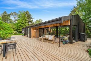 a black house with a deck with glass doors at Relaxed Lifestyle And Luxury In Melby in Melby +32 photos