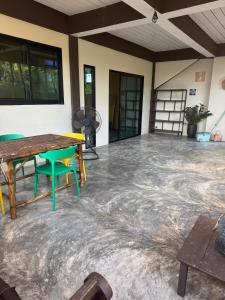 Una habitación con suelo de hormigón con una mesa y sillas. en One bedroom apartment Hin Kong, en Ko Pha Ngan