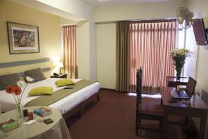 a bedroom with a large bed and a large window at Kamana Hotel in Lima