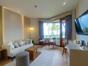 巴图KLUB BUNGA THEME PARK HOTEL的客厅里有一张白色沙发和一台电视