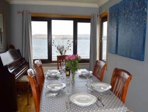 a dining room table with a view of the ocean at Clydeside Villa in Dunoon