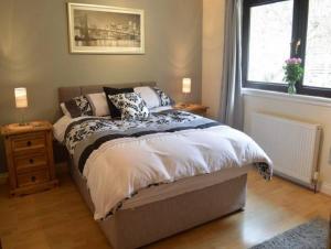 a bedroom with a bed with pillows and a window at Clydeside Villa in Dunoon