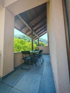 eine Terrasse mit Tisch und Stühlen auf einem Balkon in der Unterkunft Mountain Serenity and Charming Old Town Nearby by MM Host in Braşov