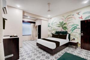 斋浦尔Super Townhouse Chandpole Metro Station Formerly Hotel Raghuraj Palace的一间卧室配有一张床和壁画墙