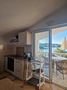 une cuisine avec une table et un balcon avec vue dans l'établissement Apartments Rora, à Rogoznica