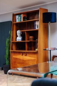 una estantería de madera con libros. en Vista Apartments Długa, en Bydgoszcz