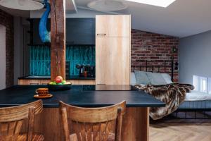 cocina con encimera con nevera y cama en Vista Apartments Długa, en Bydgoszcz