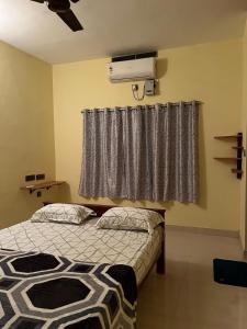 a bedroom with a bed and a air conditioner at Paradise Of Ross in Ernakulam
