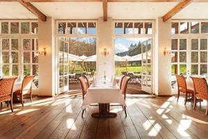 a dining room with a table and chairs and windows at Residenz Itterbach in Willingen