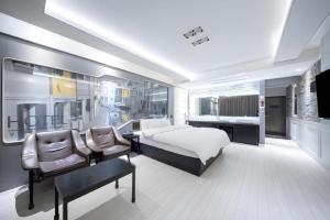 a bedroom with a bed and a desk and chairs at Pohang Hotel View in Pohang +158 photos