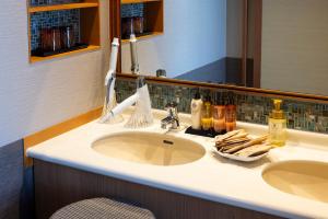 a bathroom counter with a sink and a mirror at Biwako Ryokusuitei in Otsu +133 photos