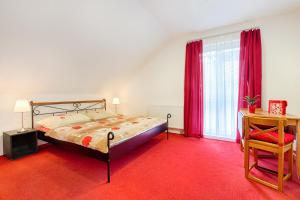 a bedroom with a bed and a table and a chair at Aparmány² in Frymburk
