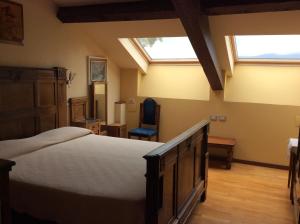 a bedroom with a bed and two skylights at Hotel Villa della Quercia in Verbania