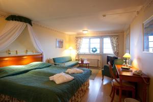 a hotel room with a bed and a desk and a room at Tällbergsgårdens Hotell in Tällberg