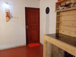 ネゴンボにあるNR homestayの木製のドアと赤い床のある部屋 +6枚の写真