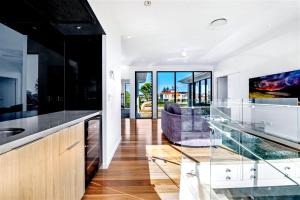 Una cocina con encimera de cristal y un sofá. en Bluewater Oasis, en Gold Coast